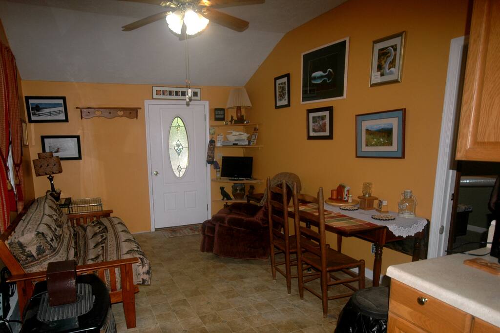 Living and dining room with Dish network cable TV also my husband is a professional photographer, and offers photos for sale in this room and throughout the apartment, come visit to view his work