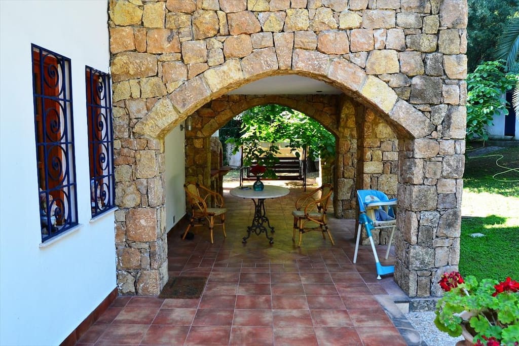 1 καθιστικο με σκεπαστρο με πετρα ανακαινισμενη απο πανω και γυρω γυρω πολυ πρασια