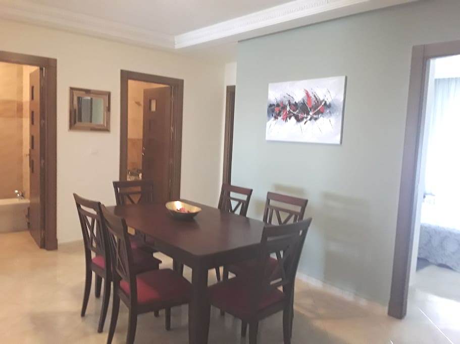 Espace pour manger. Une jolie table en bois massif avec ces 06 chaises en bois tapissé en rouge Bordeaux.