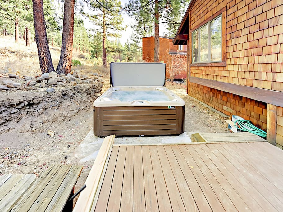 A private deck with a hot tub provides a pleasant spot to relax amidst the surrounding forest.