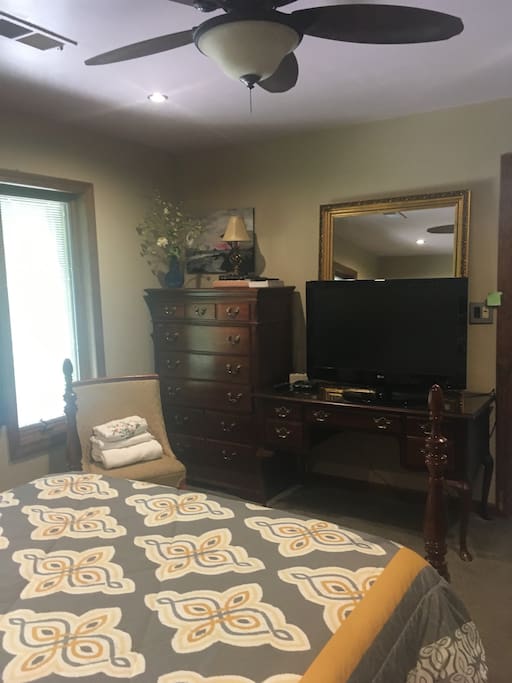 Large TV and ceiling fan in the Queen size bedroom.