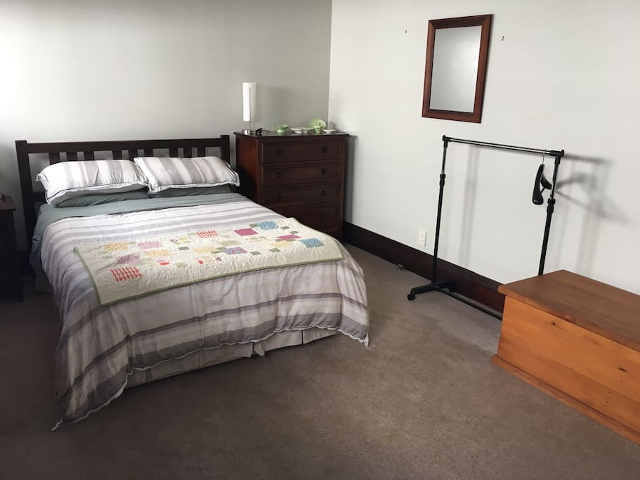 Large double bedroom with clothing rail and chest of drawers and mirror
