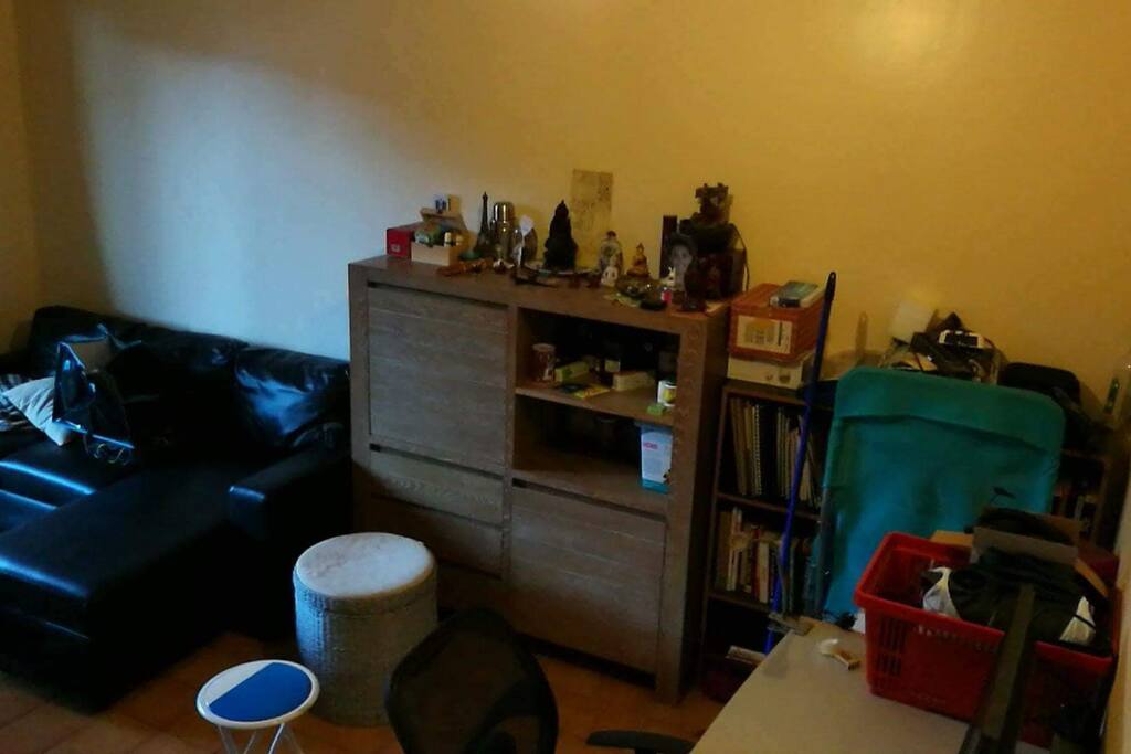 Vu du salon et le bureau dans le coin à droite avec un panier qui contient un matelas gonflable