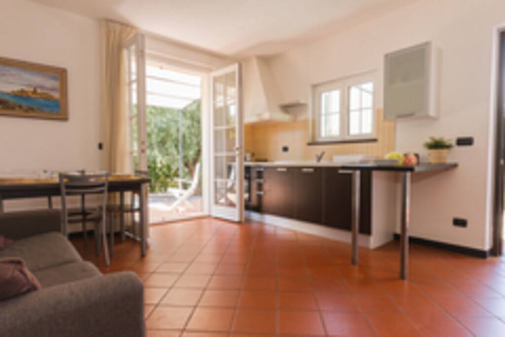 Kitchen and living room with flat screen TV dining table and sofa
