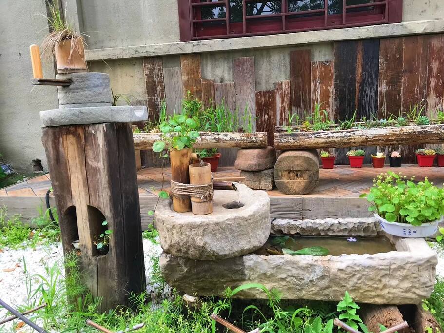 从村子里收来的石磨,猪槽做的流水器,景观