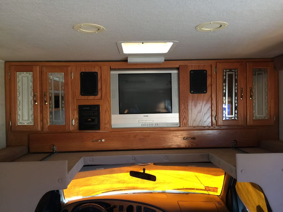 There is a twin bed above the cab (under the TV) for people with longer legs.
