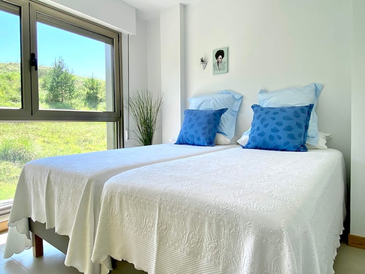 חדר שינה עם שתי מיטות בגודל 90 x 200 ס"מ המשקיפות על האזור הכפרי ועל הפסגות של אירופה.