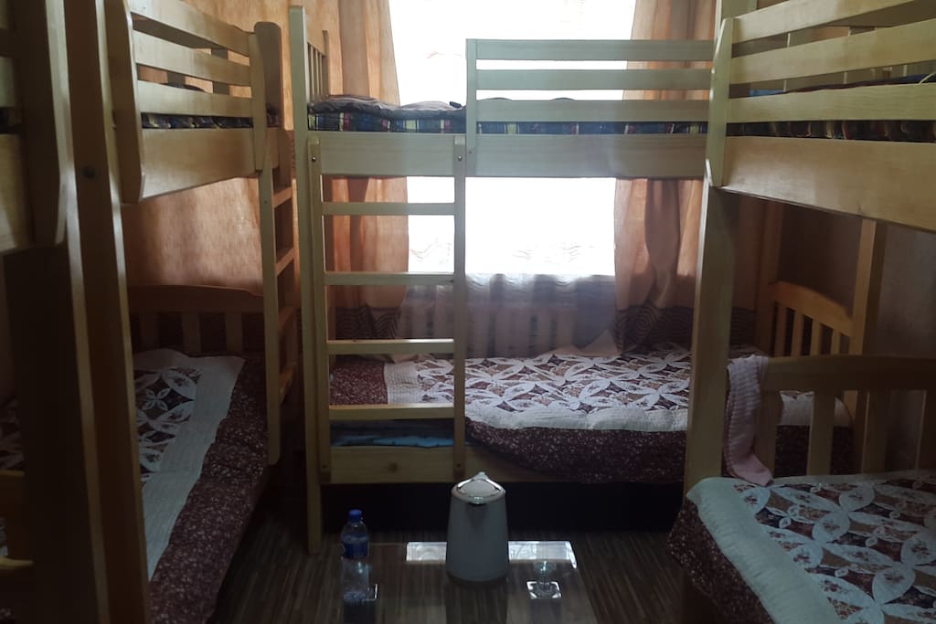 4 bunk beds in this room. 2 tables and TV. Well lit.