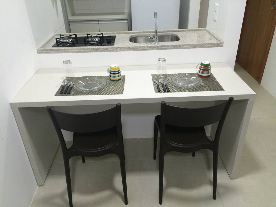 Mesa de jantar e cozinha americana.