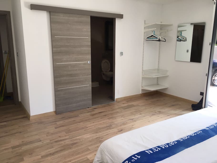 Large master bedroom with queen bed and sliding door access to italian shower toilet and large space
