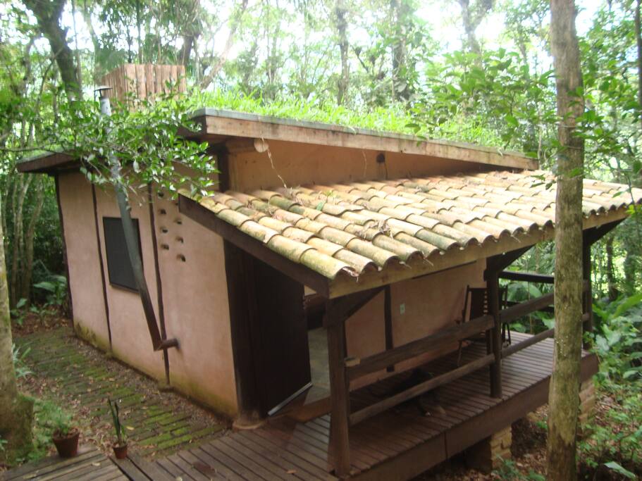 Cabana bioconstruída, com telhado verde e paredes de pau-a-pique.
