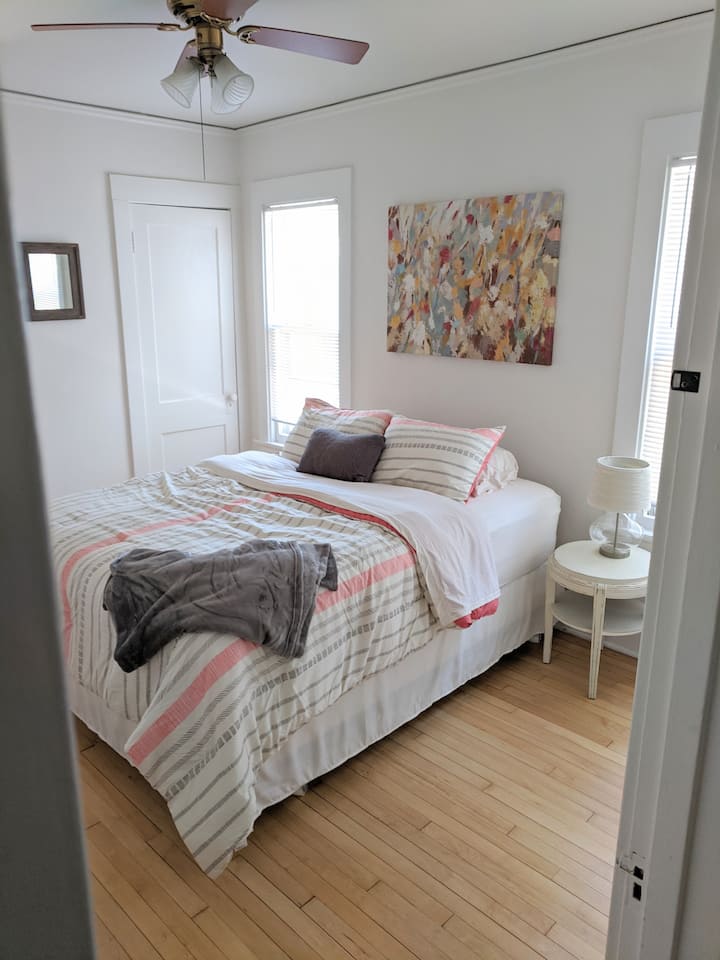 1号卧室。客厅外的宽敞卧室，配有大型步入式衣柜、梳妆台和标准双人床。  