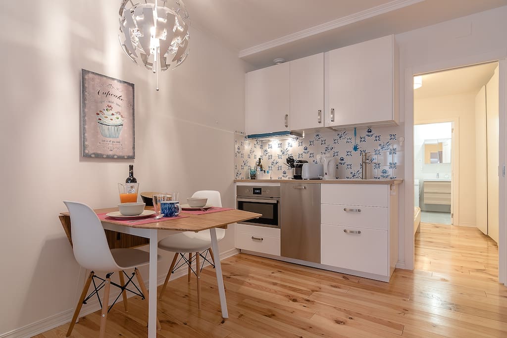 Kitchen space behind the dining table with traditional tiles