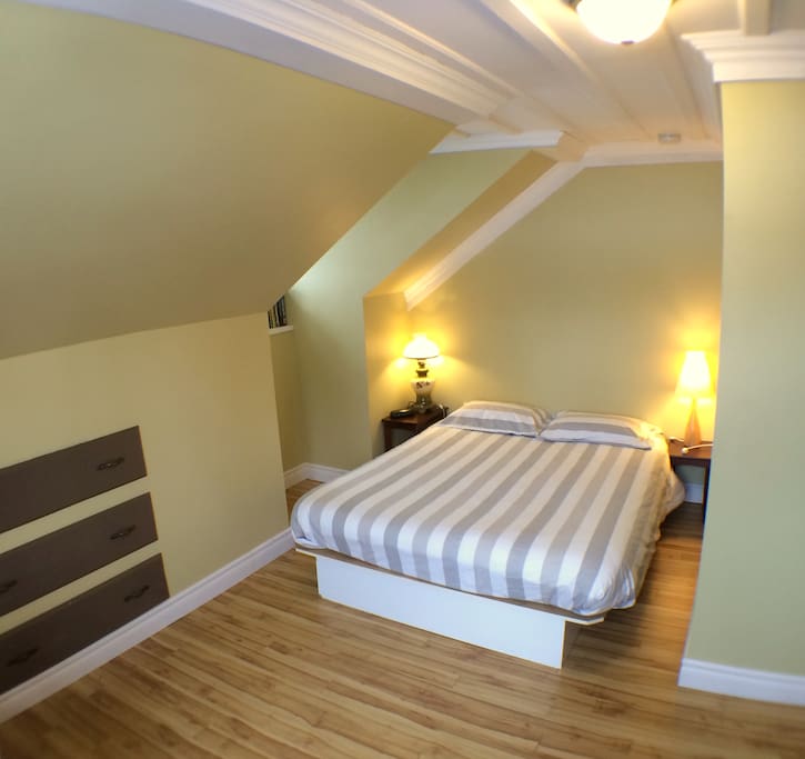 Un grand lit queen dans la chambre