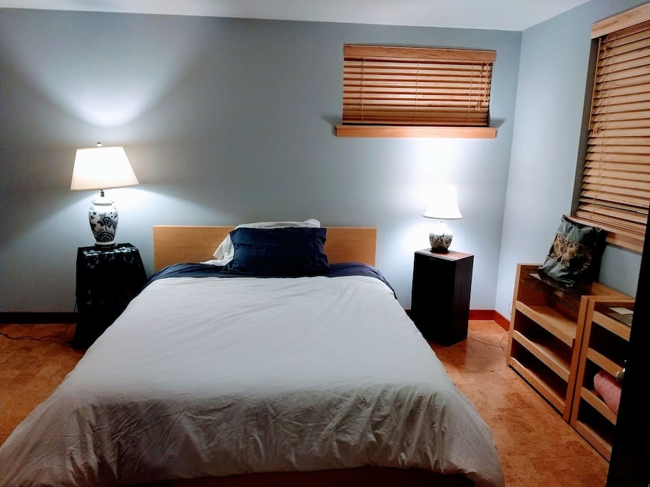 Queen size bed on cork floors with dist more covers on pillows and mattress for people allergic to dust mites.
