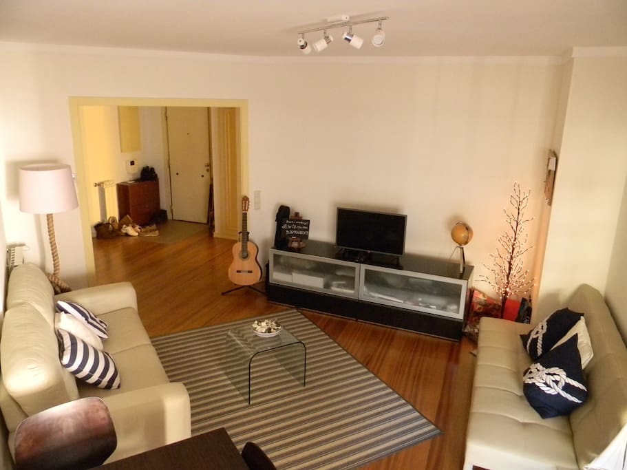 Bright and spacious living area with HD TV and sofa bed.