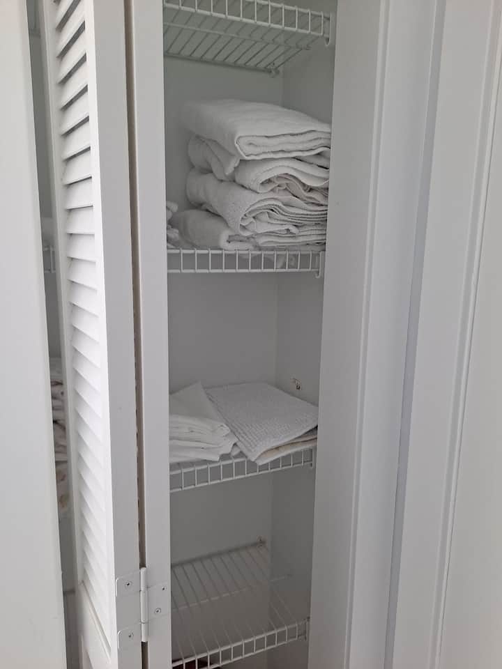 Armario de ropa de cama en el dormitorio principal, donde encontrarás algunas toallas adicionales y la ropa de cama para la cama plegable si pagas la tarifa por huésped adicional. 