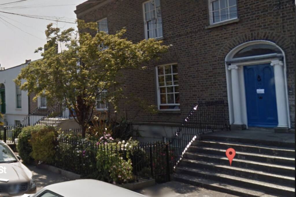 The separate, own-door entrance to the flat is through a wrought-iron gate to the front garden