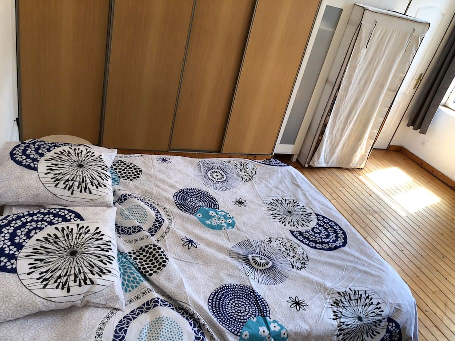 Chambre avec un lit deux places, dressing, et tv