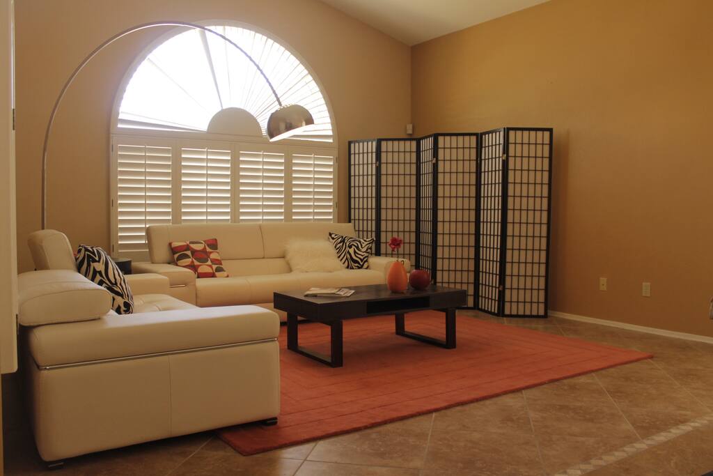 Eclectic living room with Natuzzi leather sofas, a cool arc lamp and zen screen