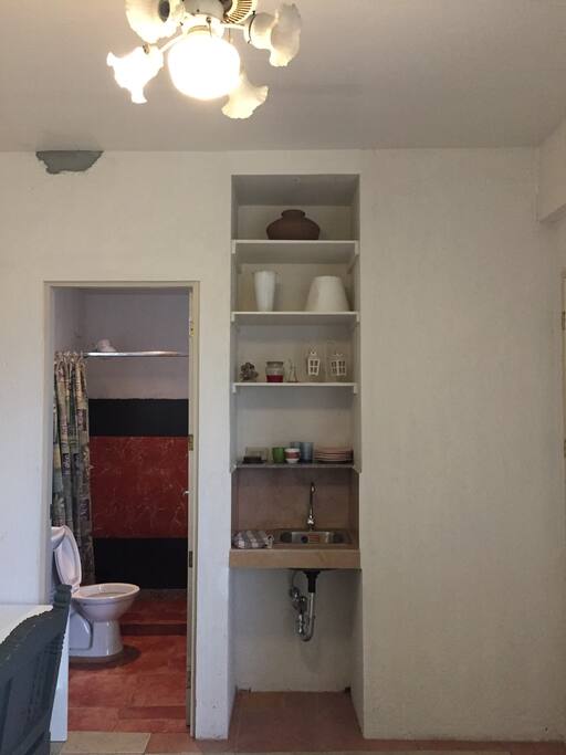 View of toilet and bar sink with heating kettle