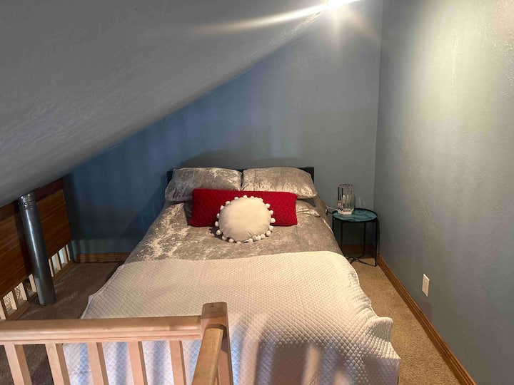 Cama tamaño grande en un espacio loft.