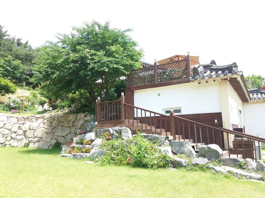 1층 잔듸마당에서 본 2층 숙소 전경과 나무계단