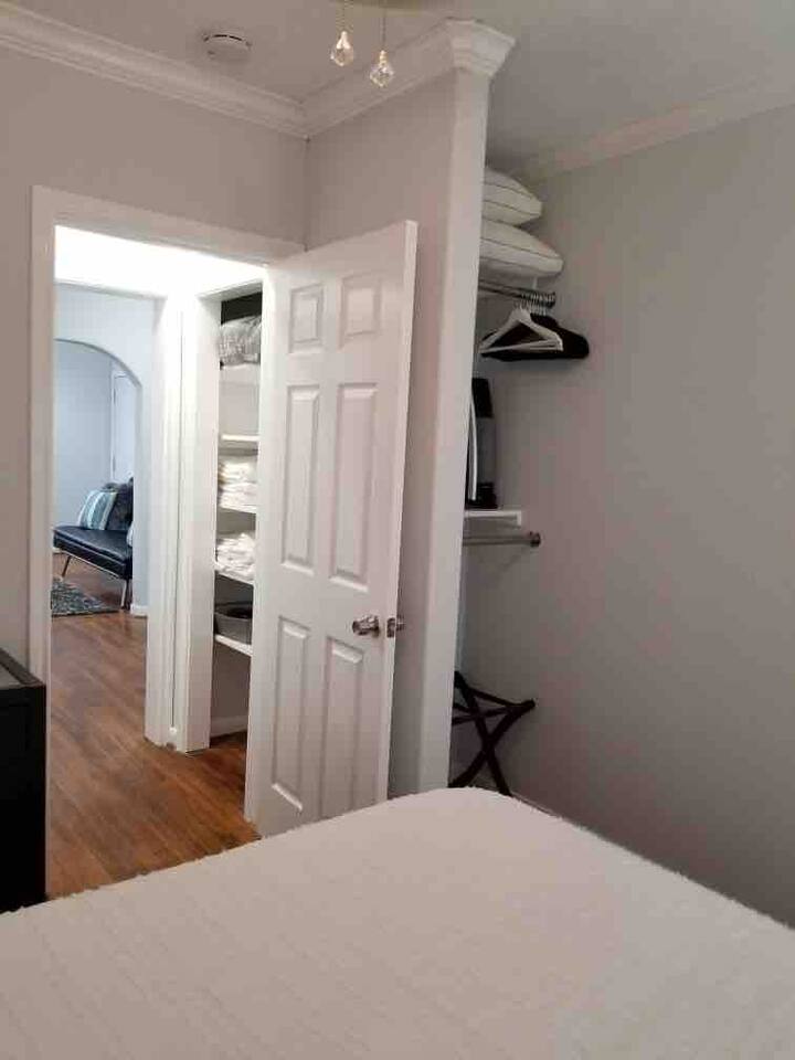 Un placard et un porte-bagages sont situés derrière la porte de la chambre
