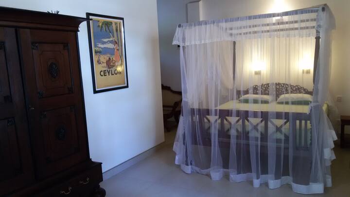 Dormitorio con cama tamaño king, moskito y aire acondicionado.