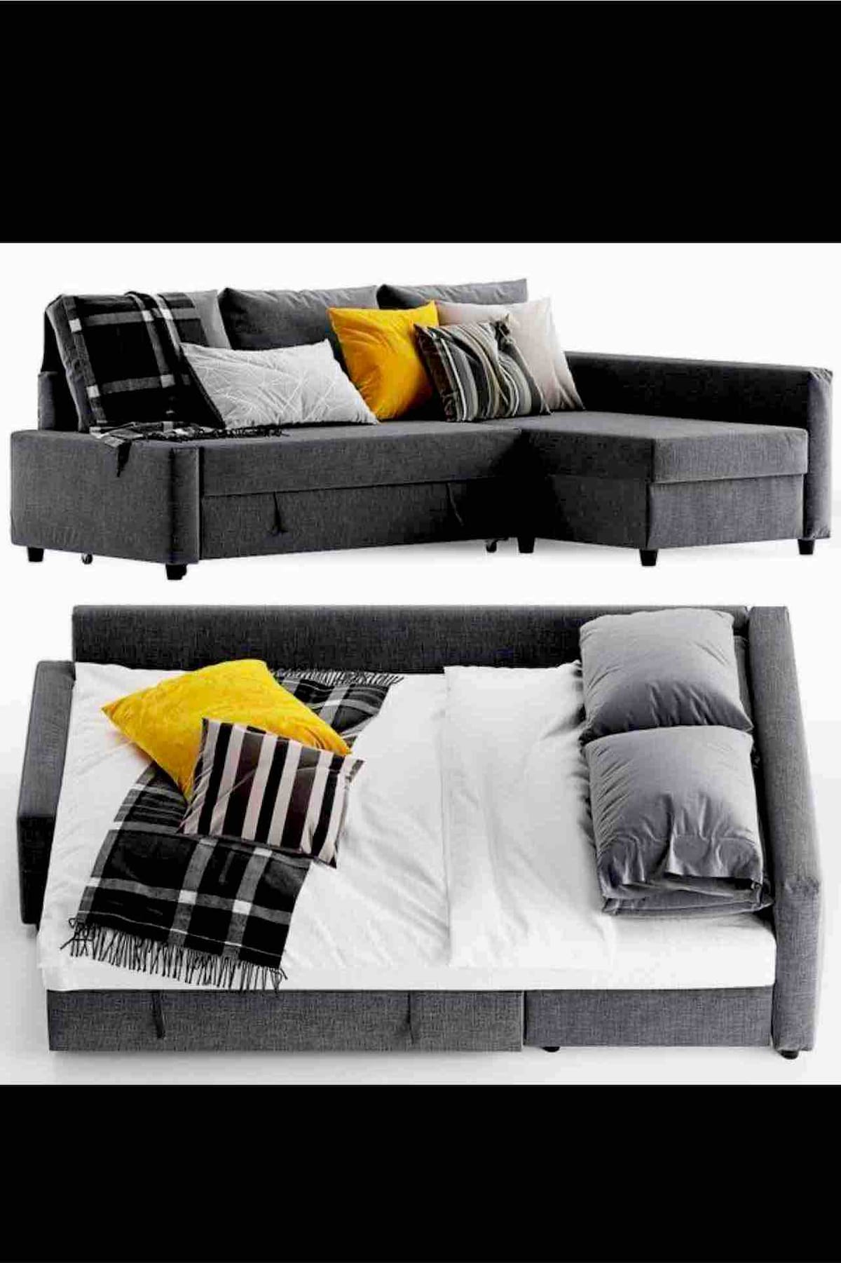 A sectional sofa in a modern grey fabric is shown in two configurations. The top section displays decorative cushions in shades of yellow and grey, while the lower section is transformed into a bed, featuring a white mattress with matching grey pillows and a cozy throw blanket.