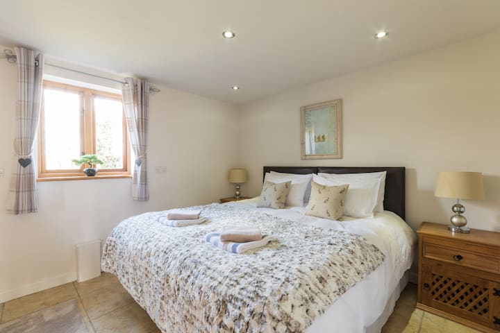 Dormitorio principal con cama tamaño king. Se puede convertir en una cama individual si es necesario. (Parte trasera de la propiedad).
