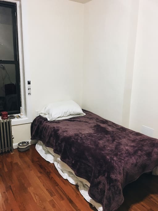 A snug bed with a heating unit right next to it.