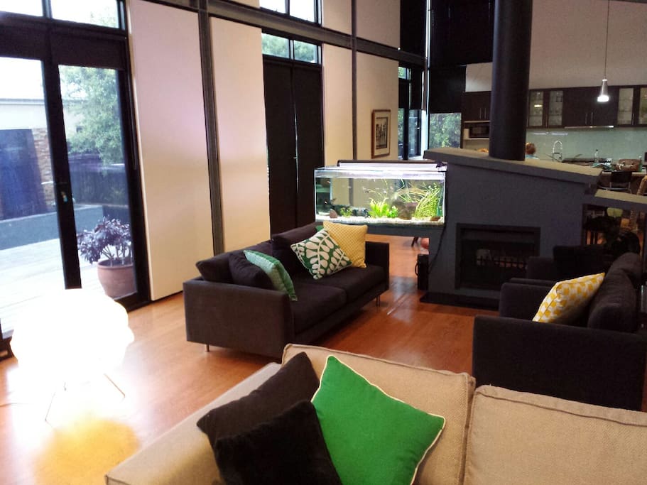 Open plan living area with large fish tank leading out to open outdoor entertainment area and hot tub.