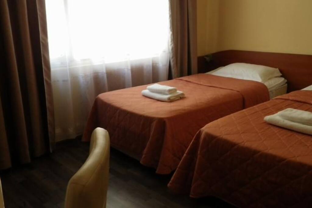 Standard room with twin beds and non-transparent curtains