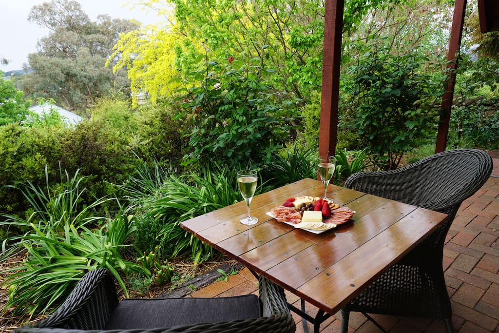 Outdoor sitting area surrounded by gardens. Under cover so may be enjoyed rain, hail or shine