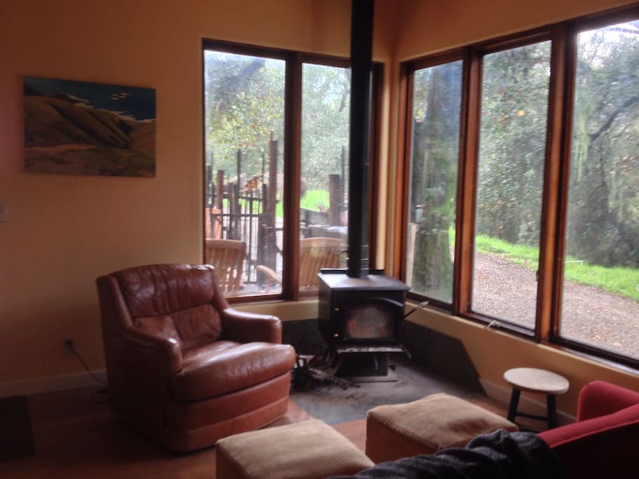 A wood stove heats the Barn on cold days. Large windows look out to covered patio, fenced yard and oaks.