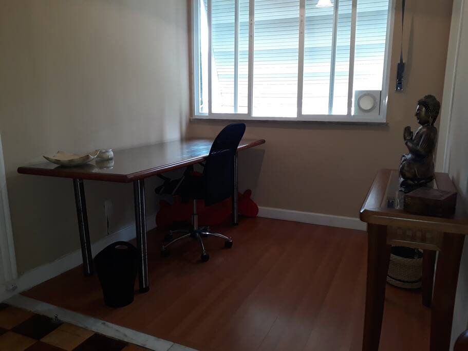 Espaço-escritório para trabalho ou estudo com WI-FI disponível e vista para a área de lazer do condomínio e a serra de Petrópolis.