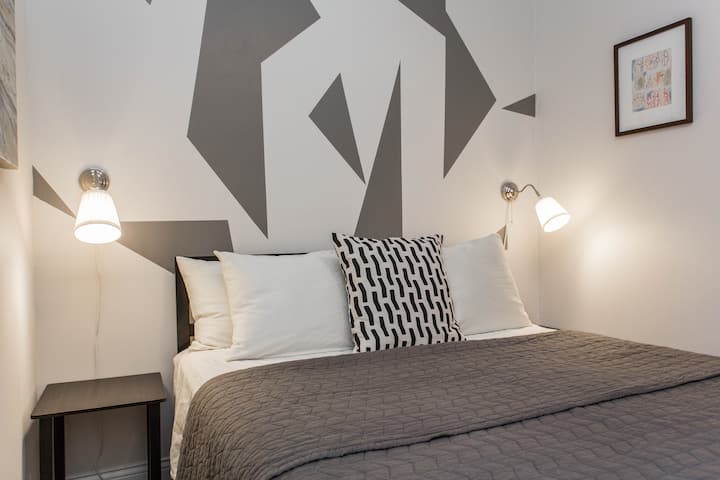 ห้องนอนแรกของ 2 ห้องตกแต่งด้วยเตียงควีนไซส์  เชิงเทียนข้างเตียง 2 อันประดับประดาด้านละด้าน