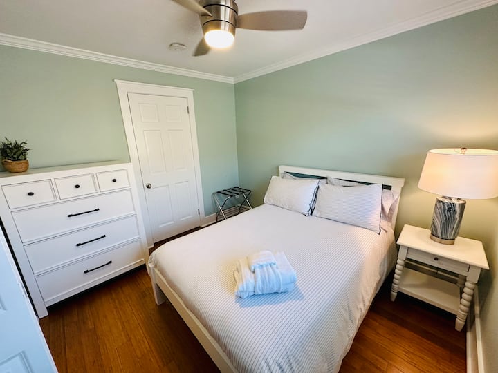 第3间卧室的双人床，配备优质床上用品、灯具、吊扇和行李架。