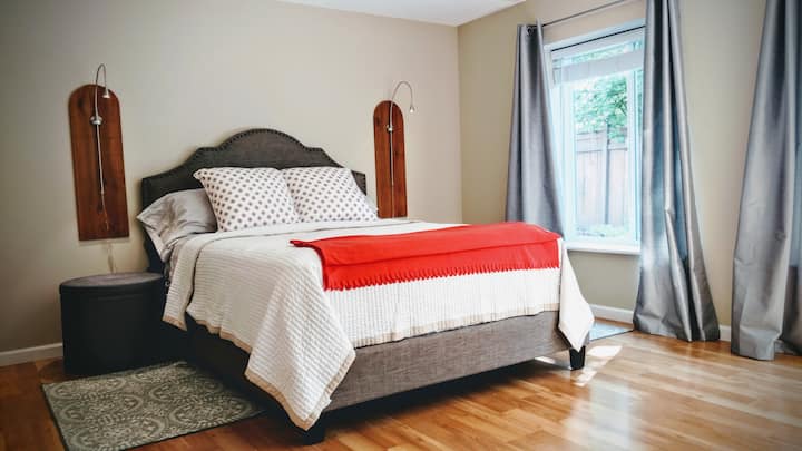 חדר שינה מרווח עם מזרן קווין סייז איכותי וכיסוי מזרן נשלף לנשימה. מפלס אור יום נמוך יותר מספק הרבה אור טבעי.