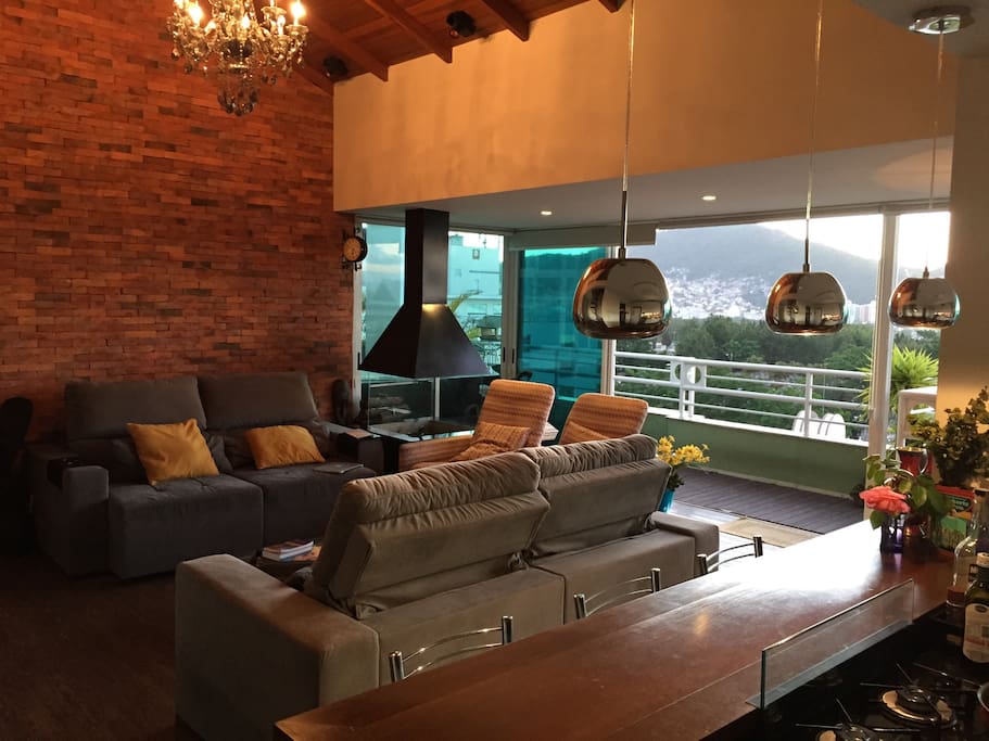 Ampla sala com cozinha americana e vista para o mar de dentro ao apartamento.