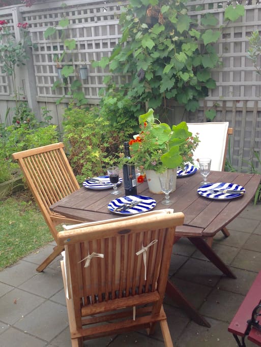 French doors lead to a lovely courtyard private garden with outdoor eating area and BBQ