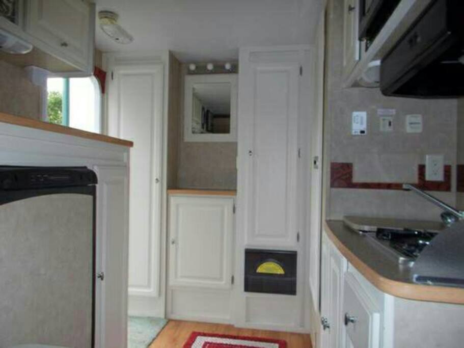 All you need in one room! Vanity with lights & mirror; dishes are in cabinet under it.