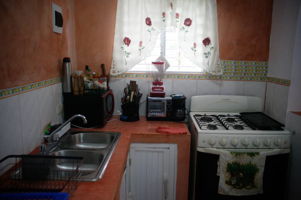Cocina completa con microondas, horno y cafetera.