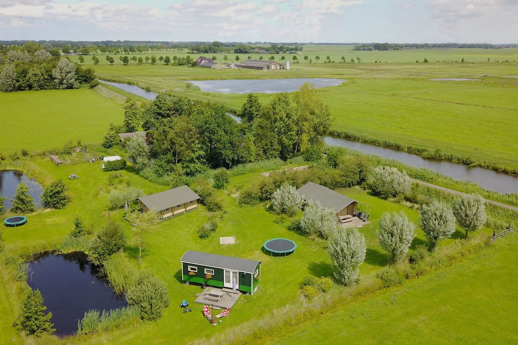Overzicht van het terrein met twee safari tenten en een pipowagen
