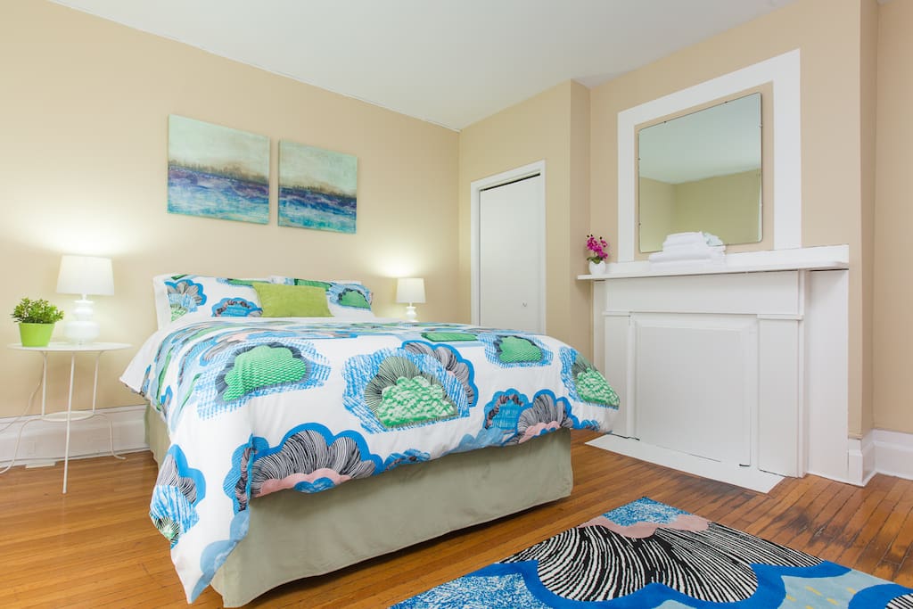 First bedroom on main floor, featuring cheerful decor and a brand new high-end queen bed for cozy sleeps.