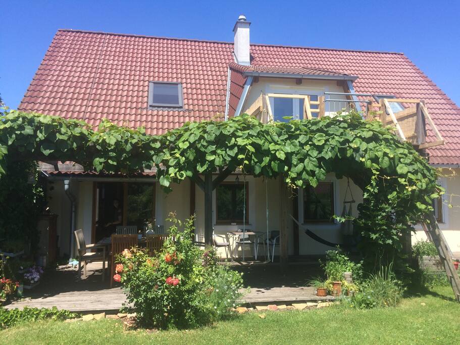 Gartenansicht auf Erdgeschoss-Terrasse und Obergeschoss-Balkon