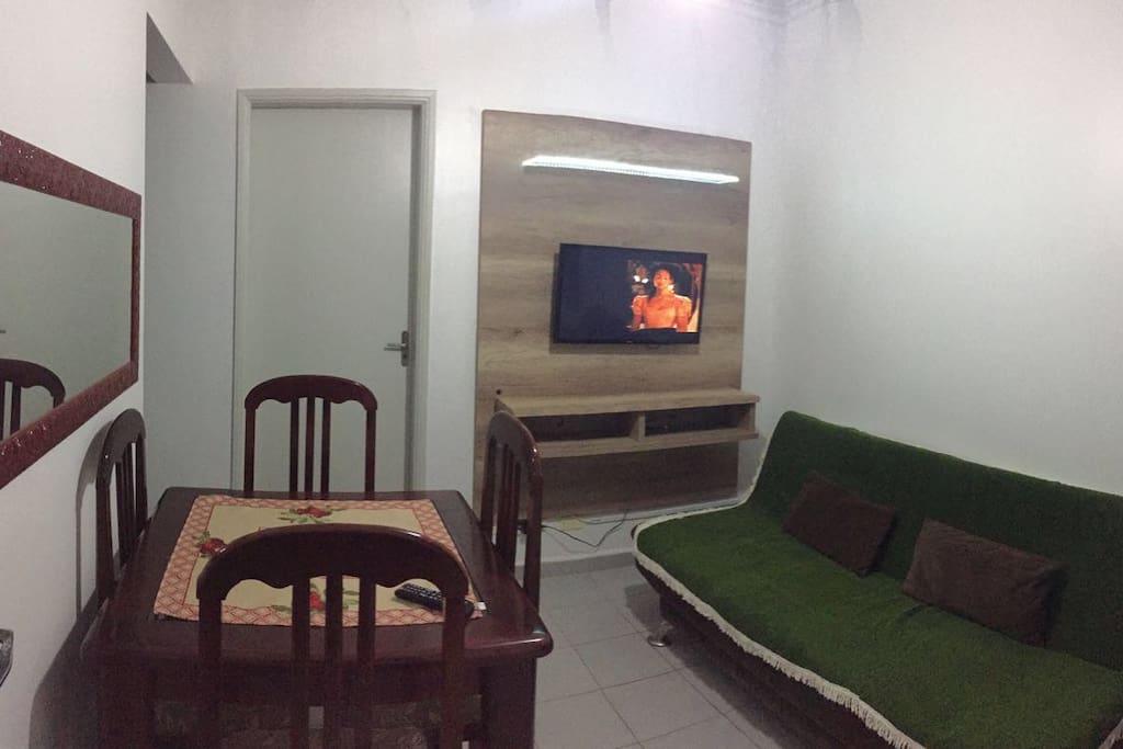 Sala com TV, sofá cama e Mesa de Jantar.