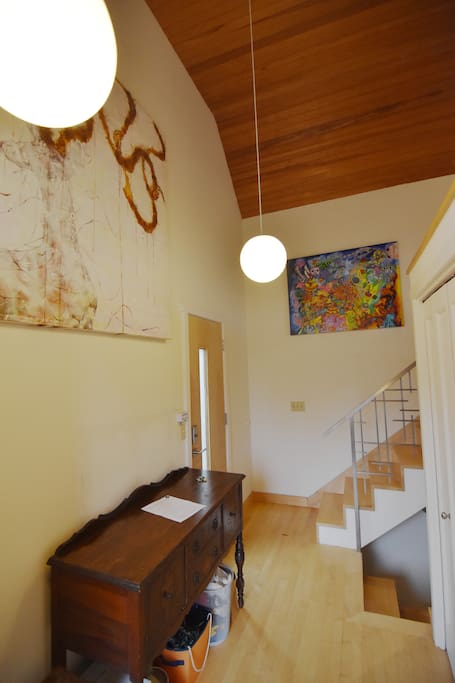 View entering the front door. Bedroom and bathroom are upstairs. Living room and kitchen are downstairs.