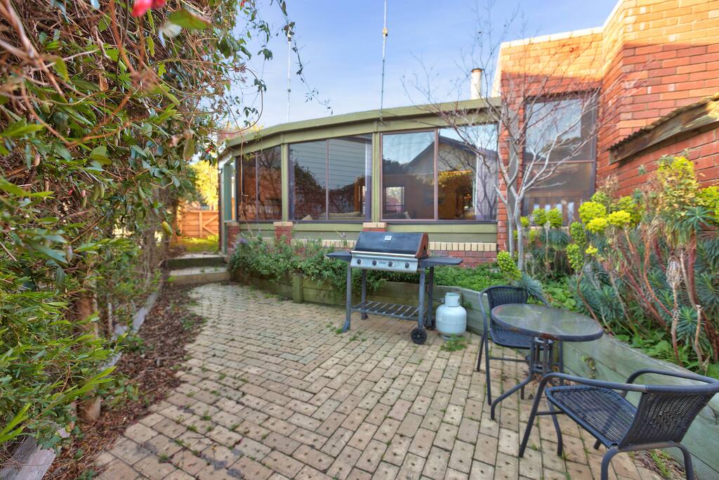 Sunny outdoor BBQ dining area with water views.